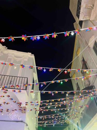 a string of christmas lights hanging from a building at Palazzo dei Gigli Puglia - house with heatable rooftop-Pool in Ugento