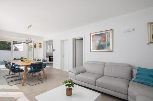 a living room with a couch and a table at Epetium Beach Villa in Split