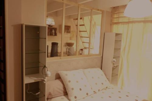 a small bedroom with a bed and a mirror at Maison indépendante climatisée dans quartier calme in Villeneuve-lès-Avignon