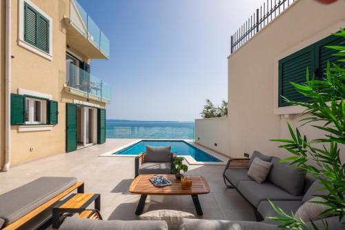 a patio with a couch and a table on a building at Epetium Beach Villa in Split