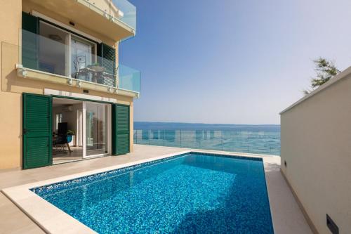 a swimming pool on the side of a house at Epetium Beach Villa in Split