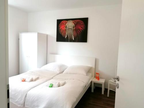 a bedroom with two beds and an elephant picture on the wall at Wohnung in Herne Zentral mit Küche, Netflix, Disney Plus, DAZN in Herne