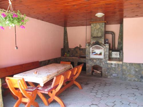 a dining room with a table and a fireplace at Vila La Izvor in Petreşti