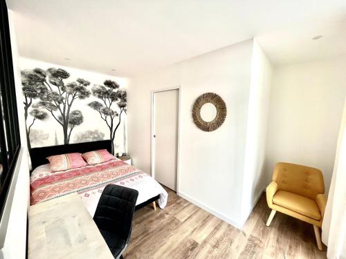 a bedroom with a bed and a table and a chair at STUDIO IBIZA - HYPER CENTRE LORIENT in Lorient
