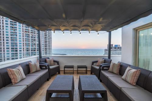 a balcony with couches and a view of the ocean at Seaview Rooftop in San Stefano in Alexandria