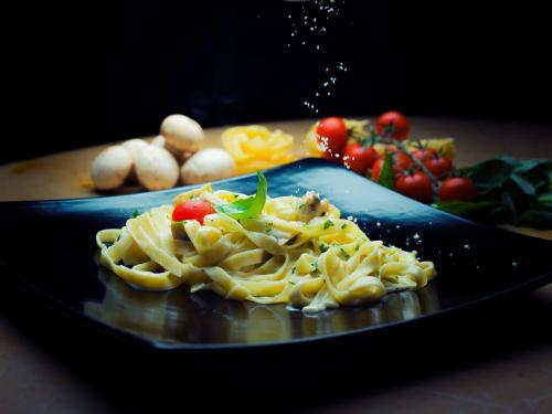 a plate of food with pasta and vegetables on a table at Sheraton Dammam Hotel & Convention Centre in Dammam