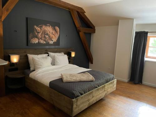 ein Schlafzimmer mit einem Bett mit einem Bild eines Löwen an der Wand in der Unterkunft Ferme de la Dhuys 