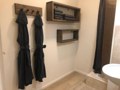 a bathroom with black umbrellas hanging on the wall at Ferme de la Dhuys 