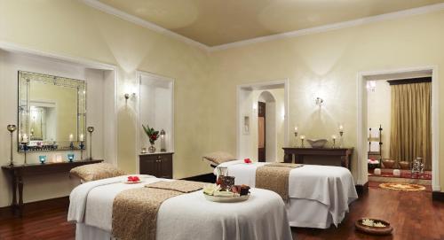 a hotel room with two beds and a mirror at Taj Nadesar Palace in Varanasi