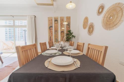 a dining room with a table with plates on it at Nabeel Homes - Seaview Rooftop - San Stefano in Alexandria