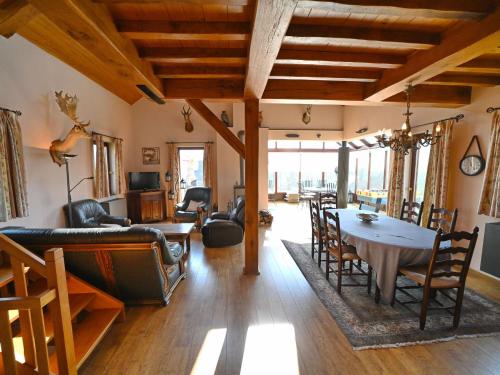 een woonkamer met een tafel en een eetkamer bij Le Hibou is a very spacious holiday home for 6 adults and 2 children in Noiseux