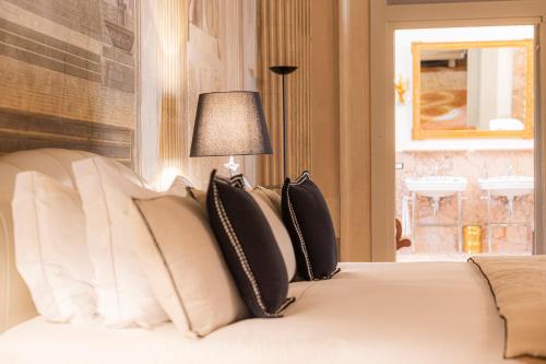 a bedroom with a bed with black and white pillows at Corte Realdi - Palazzo Camozzini in Verona