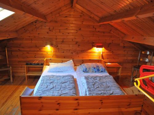 een slaapkamer met een bed in een houten kamer bij Cosy Holiday Home in Noiseux with Large Garden in Noiseux
