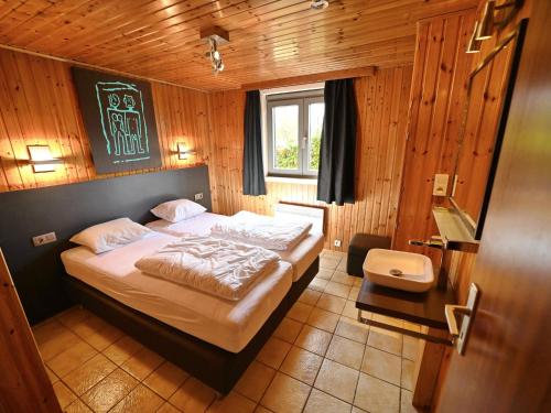 1 dormitorio con 1 cama en una habitación de madera en Terrace, Garden, BBQ, Sauna, Jacuzzi!! For a happy and rejuvenating time, en Noiseux