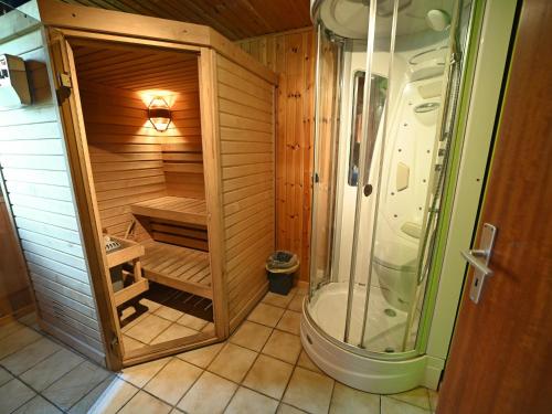 een houten badkamer met een douche en een toilet bij Terrace, Garden, BBQ, Sauna, Jacuzzi!! For a happy and rejuvenating time in Noiseux