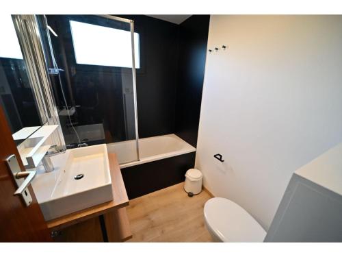 łazienka z toaletą, umywalką i wanną w obiekcie Cozy Holiday Home in Somme-Leuze with Private Garden w mieście Noiseux