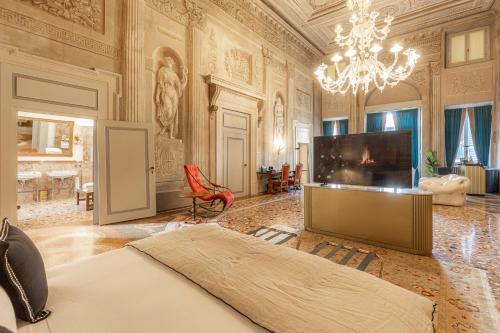 a bedroom with a bed and a flat screen tv at Corte Realdi - Palazzo Camozzini in Verona
