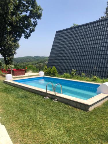a swimming pool in the grass next to a building at Happy House Bungalov Three-Room SPA JAKUZİ Lake view in Sapanca B2 in Sapanca