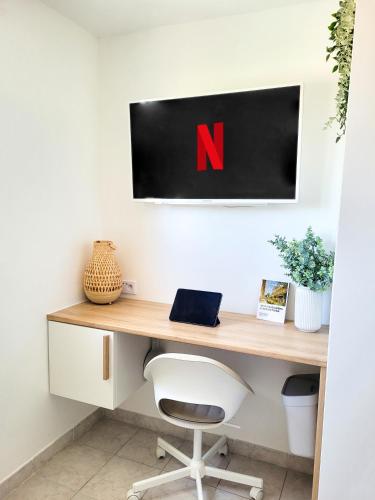 - un bureau avec une chaise et une pancarte sur le mur dans l'établissement Chambre climatisée lit double - Proche tram & Centre, à Montpellier