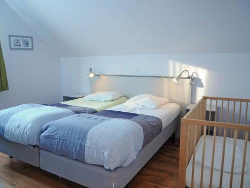 a bedroom with two twin beds and a crib at Beautiful Holiday Home in Barvaux-sur-Ourthe with Sauna in Barvaux