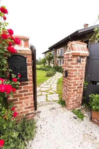 a brick wall with a gate and flowers at Cascina Arcangelo Raffaele in Verduno