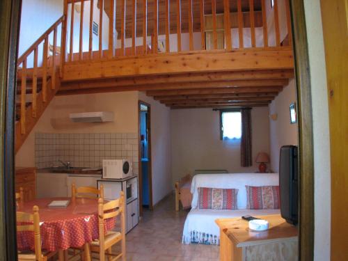 a room with a kitchen and a bedroom with a staircase at Lei Canissouns in Castellane
