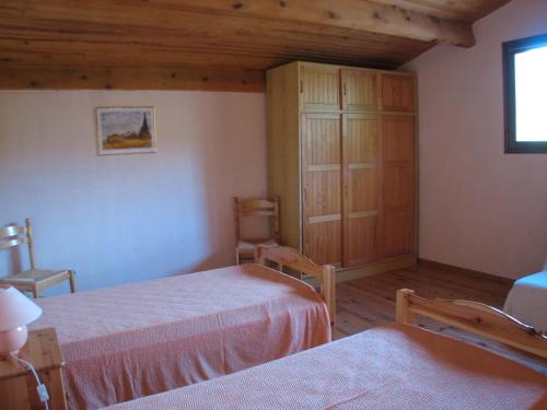 1 dormitorio con 2 camas y armario de madera en Lei Canissouns, en Castellane