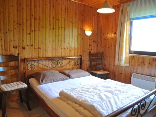 Attractive holiday home in Hampteau with garden في Hampteau: غرفة نوم بسرير في جدار خشبي