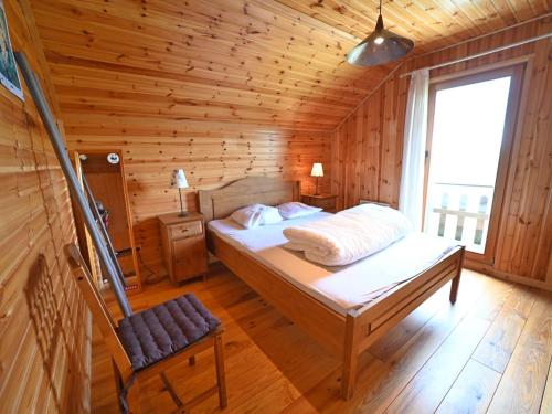 um quarto com uma cama num chalé de madeira em Pleasant detached chalet with sauna near Durbuy em Biron