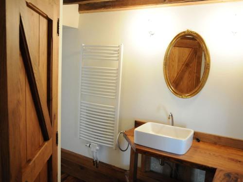 a bathroom with a white sink and a mirror at Stone-built holiday home in Werpin with garden in Werpin