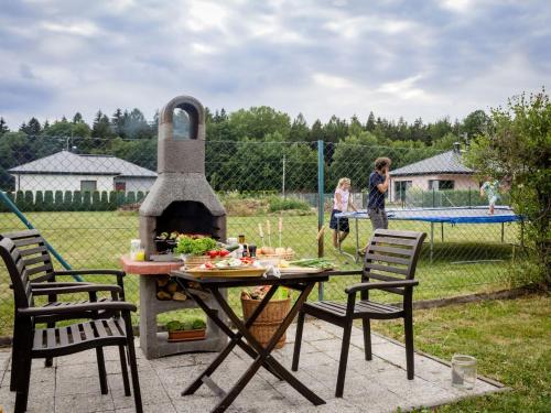 a table and chairs with a pizza oven in a yard at Apartment in Nemojov near Forest and Pool in Horní Nemojov