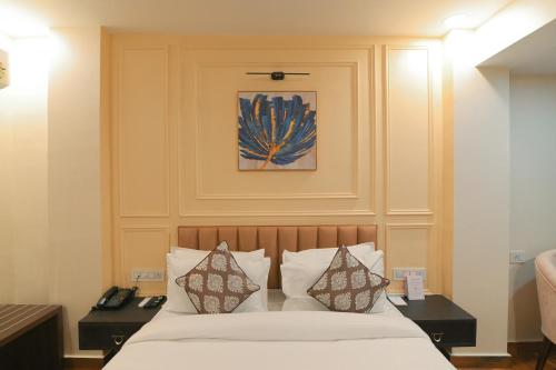 a bedroom with a bed with pillows and a painting at Hotel Swagat Suites in Haridwār