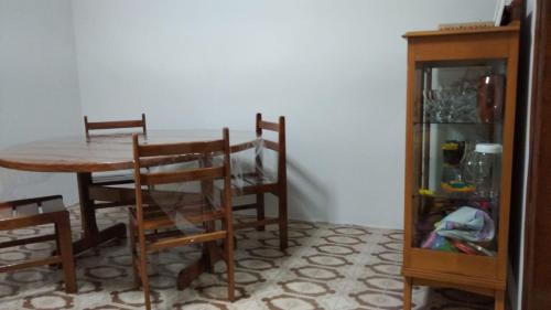 ein Esszimmer mit einem Tisch und Stühlen sowie einem Schrank in der Unterkunft Confortável e espaçosa in Bebedouro