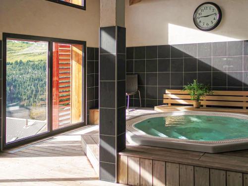 - un bain à remous dans une pièce dotée d'une horloge murale dans l'établissement Apartment in Flaine with Pool and Sauna, à Arâches-la-Frasse