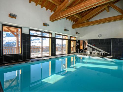 - une piscine d'eau bleue dans une chambre avec fenêtres dans l'établissement Apartment in Flaine with Pool and Sauna, à Arâches-la-Frasse