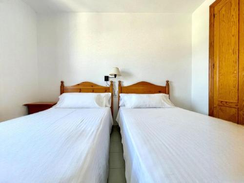 two beds sitting next to each other in a bedroom at Beachfront apartment in Roquetas de Mar with communal pool in Roquetas de Mar