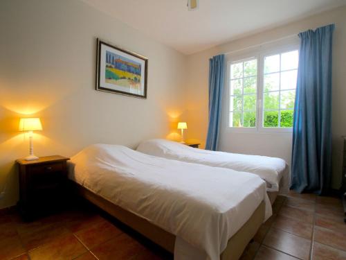 1 Schlafzimmer mit 2 Betten und einem Fenster mit blauen Vorhängen in der Unterkunft Tasteful villa with Wi-Fi, located in natural surroundings in Vasles