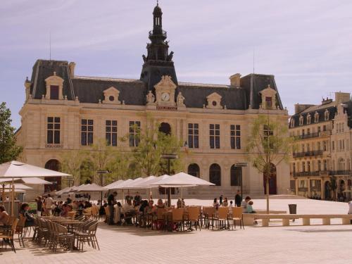 people sitting at tables in front of a large building at Villa in France with Private Pool in Vasles