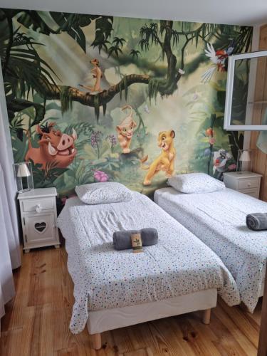 una camera con 2 letti e un murale di scimmie di Villa climatisée avec piscine à LEGE CAP FERRET a Lège-Cap-Ferret