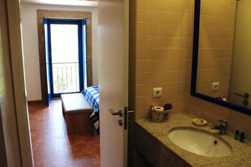 a bathroom with a sink and a mirror at Caramulo - Casas do Espigueiro in Macieira de Alcoba