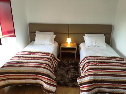 two beds sitting next to each other in a room at Caramulo - Casas do Espigueiro in Macieira de Alcoba