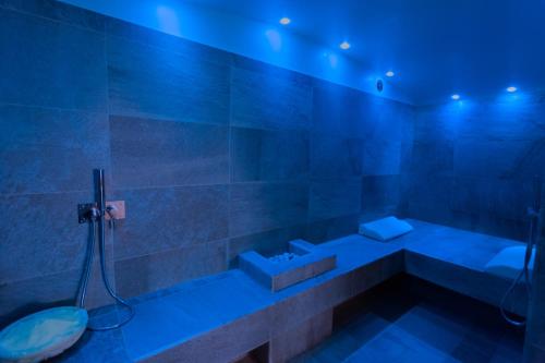 a bathroom with a tub and a sink and blue lighting at Hotel Mamiani & Relaxing Spa Urbino in Urbino