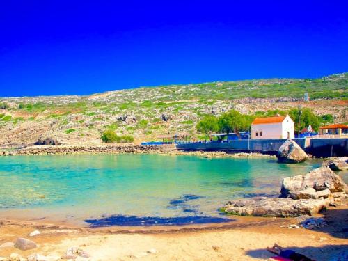 a body of water with a house and a beach at Villa in Gerani with Pool and Sea Views in Gerani