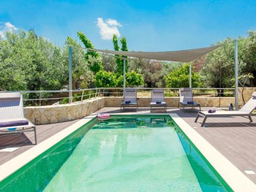 a swimming pool with two lounge chairs and a patio with a table and two chairs at Villa in Gerani with Pool and Sea Views in Gerani