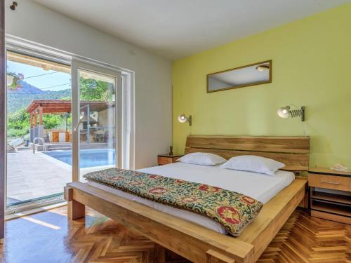 a bedroom with a large bed and a sliding glass door at Villa in Solin with Private Pool and Garden in Solin