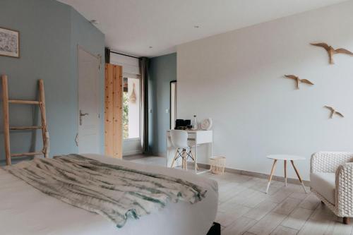 a bedroom with a bed and a table and a chair at Villa Calma - Maison d'hôtes & Spa in Mottier
