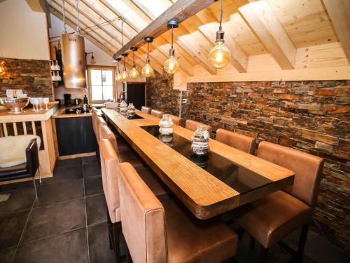 une salle à manger avec une grande table et des fauteuils en cuir dans l'établissement Chalet in Valloire near Ski Slopes, à Valloire
