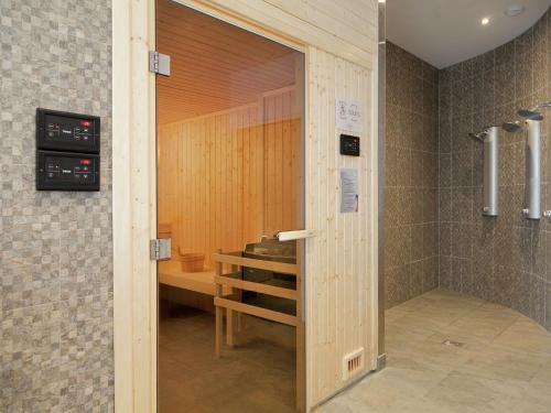 a bathroom with a shower with a wooden door at Modern apartment near the ski lift in an authentic village in Sainte-Foy-Tarentaise