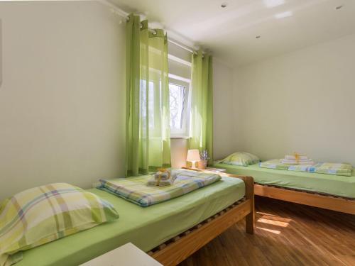 two beds in a room with green curtains at Villa in Kujici near Beach with Pool in Hreljići