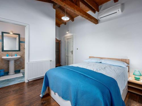 - une chambre avec un lit bleu et un lavabo dans l'établissement Beautiful villa with swimming pool and fenced garden, à Tinjan